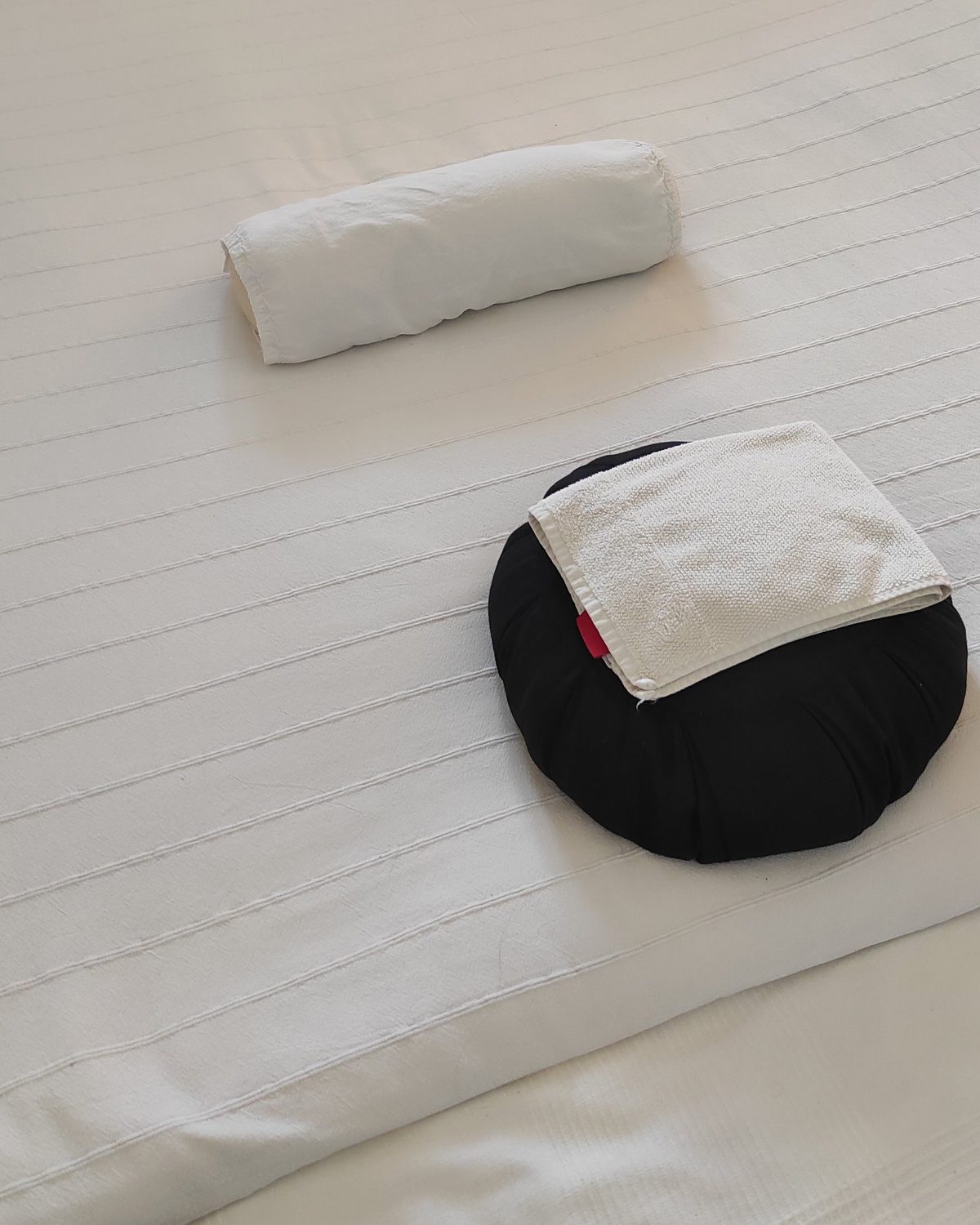 Zafu con asciugamano e cuscino neckroll sul futon